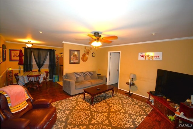 living area with ornamental molding, wood finished floors, and a ceiling fan