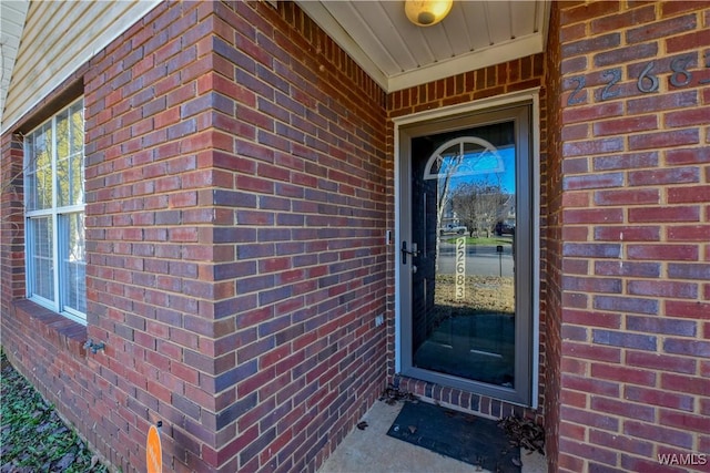 entrance to property featuring brick siding