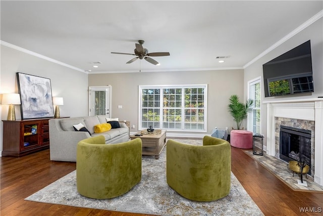 living room featuring a high end fireplace, ornamental molding, a ceiling fan, and wood finished floors