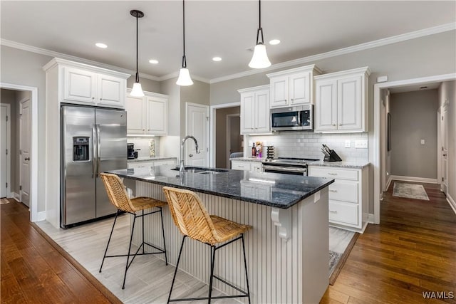 kitchen featuring a sink, appliances with stainless steel finishes, light wood-style flooring, and white cabinetry