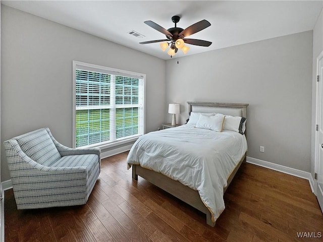 bedroom with visible vents, wood finished floors, baseboards, and ceiling fan