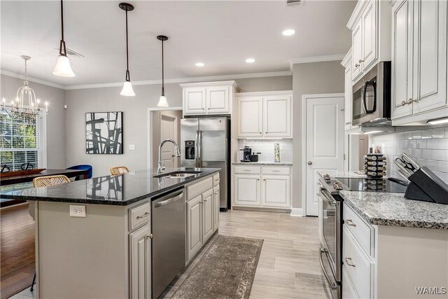 kitchen with backsplash, light wood-style flooring, stainless steel appliances, white cabinetry, and a sink