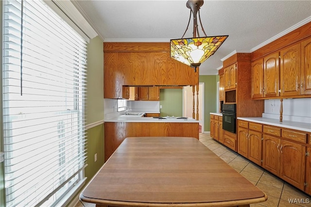 kitchen featuring hanging light fixtures, crown molding, oven, and light tile patterned floors