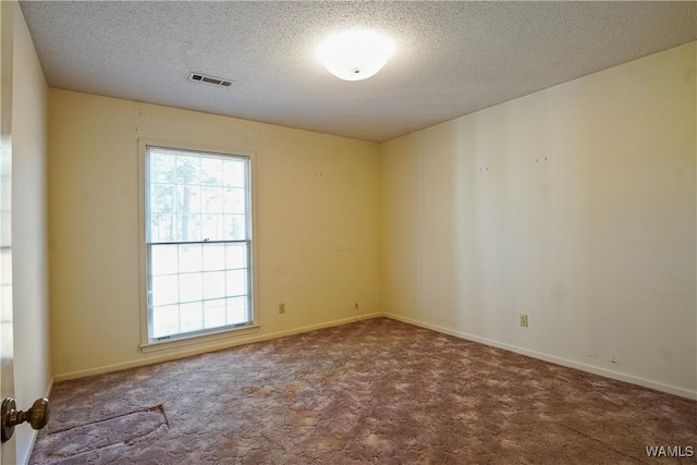 carpeted spare room featuring a textured ceiling