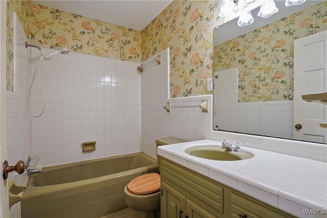 full bathroom with tiled shower / bath combo, vanity, tile walls, and toilet