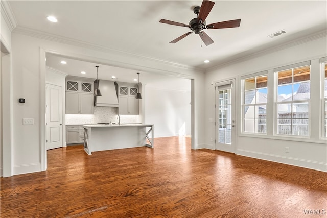 unfurnished living room with ceiling fan, dark hardwood / wood-style flooring, and crown molding