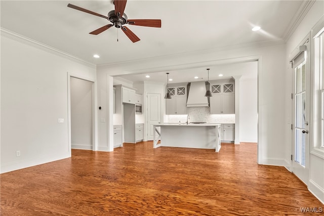 unfurnished living room featuring ceiling fan, crown molding, and light hardwood / wood-style flooring