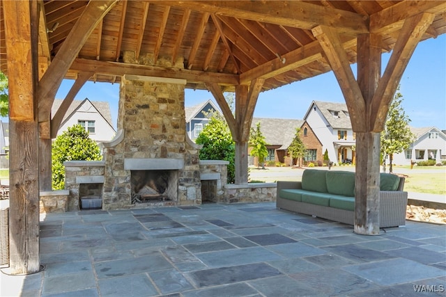 view of patio with a gazebo and an outdoor living space with a fireplace