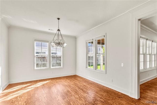 unfurnished dining area with hardwood / wood-style flooring, a notable chandelier, and crown molding