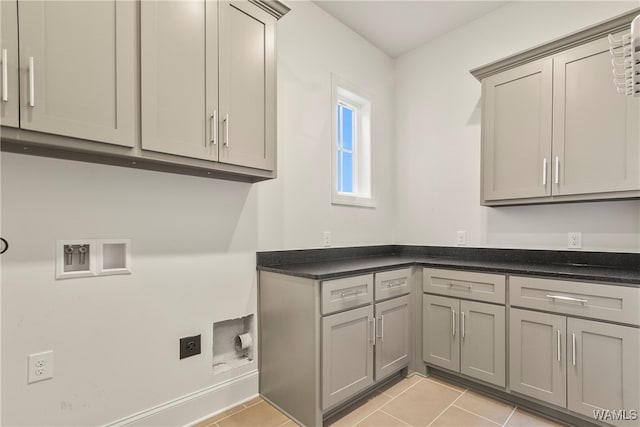 laundry area featuring washer hookup, electric dryer hookup, light tile patterned flooring, and cabinets