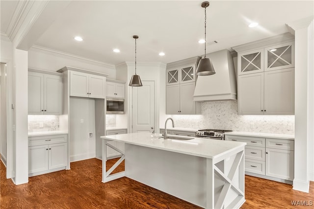 kitchen featuring appliances with stainless steel finishes, a center island with sink, hardwood / wood-style flooring, and sink