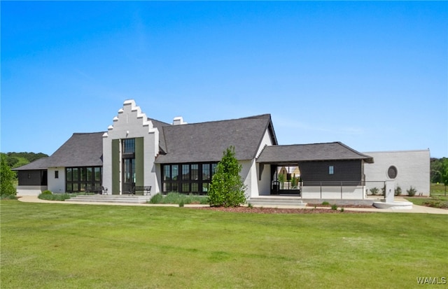 rear view of property featuring a lawn