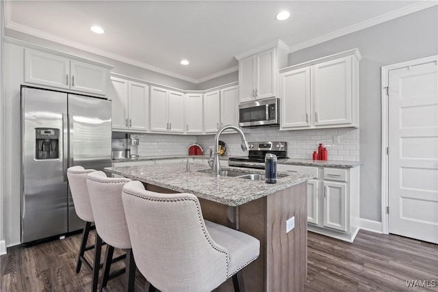 10488 Nicole St, Vance, AL 35490 - kitchen featuring appliances with stainless steel finishes, dark wood-style flooring, a center island with sink, white cabinets, and recessed lighting