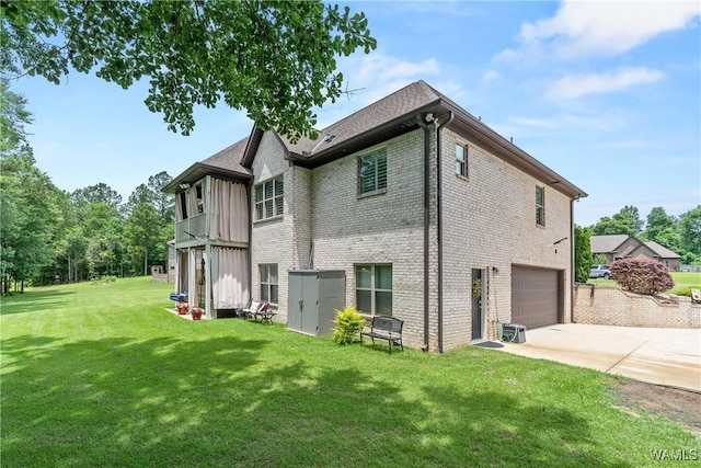 10488 Nicole St, Vance, AL 35490 - back of property featuring a garage, concrete driveway, brick siding, and a yard