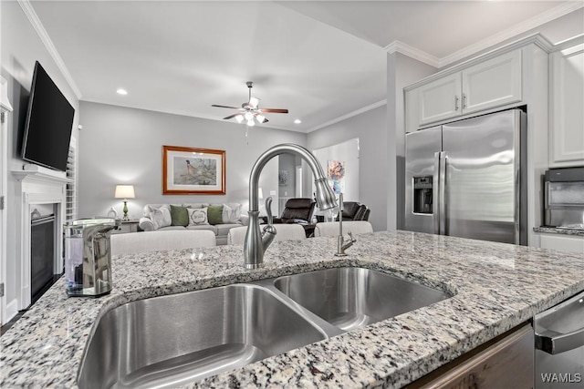 10488 Nicole St, Vance, AL 35490 - kitchen with appliances with stainless steel finishes, recessed lighting, light stone countertops, ceiling fan, and a fireplace