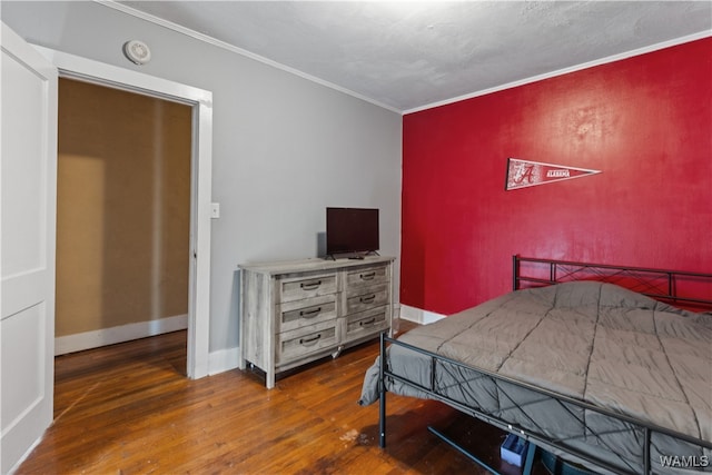 bedroom with dark hardwood / wood-style flooring and crown molding