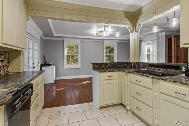 kitchen featuring cream cabinetry, dishwasher, light hardwood / wood-style floors, and dark stone counters