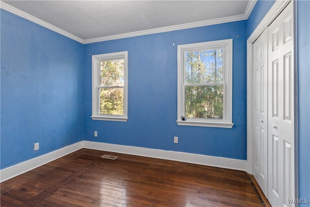 unfurnished room featuring dark hardwood / wood-style flooring, ornamental molding, and a textured ceiling