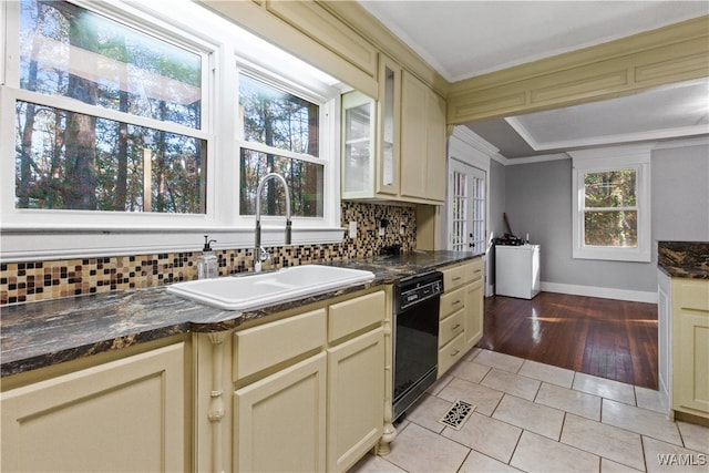 kitchen with light wood-type flooring, tasteful backsplash, sink, dishwasher, and cream cabinetry