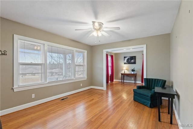 living area featuring ceiling fan and light wood-type flooring