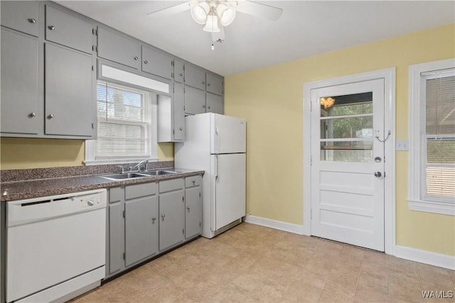 kitchen with gray cabinetry, sink, white appliances, and a wealth of natural light