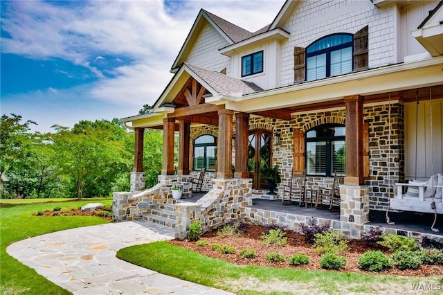 10300 Legacy Ln, Northport, AL 35475 - view of exterior entry with a porch, board and batten siding, a shingled roof, and stone siding