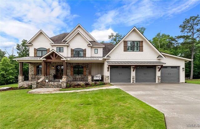 10300 Legacy Ln, Northport, AL 35475 - craftsman-style house featuring a standing seam roof, driveway, a front lawn, covered porch, and stone siding