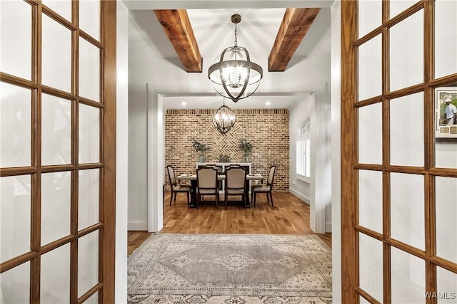 10300 Legacy Ln, Northport, AL 35475 - dining room with a chandelier, wood finished floors, beamed ceiling, brick wall, and baseboards