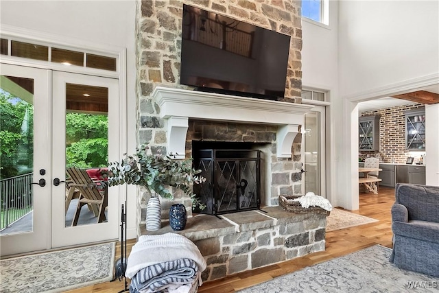 10300 Legacy Ln, Northport, AL 35475 - living room with a stone fireplace, french doors, a high ceiling, and wood finished floors