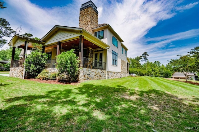 10300 Legacy Ln, Northport, AL 35475 - back of house featuring a lawn, a chimney, board and batten siding, and stone siding
