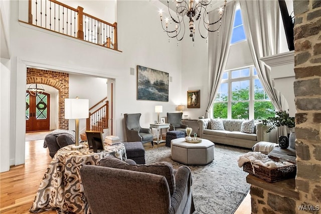 10300 Legacy Ln, Northport, AL 35475 - living room with a high ceiling, a chandelier, wood finished floors, stairs, and arched walkways
