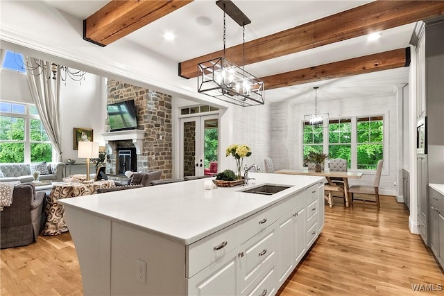 10300 Legacy Ln, Northport, AL 35475 - kitchen featuring a sink, a chandelier, open floor plan, beamed ceiling, and light wood-type flooring