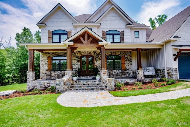10300 Legacy Ln, Northport, AL 35475 - view of front of house featuring board and batten siding, a porch, a front lawn, stone siding, and an attached garage