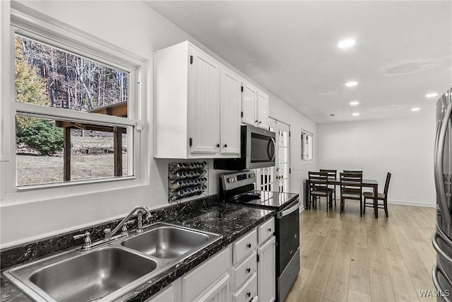 kitchen with light wood-style flooring, appliances with stainless steel finishes, white cabinetry, a sink, and recessed lighting