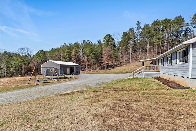 view of yard featuring gravel driveway and a forest view