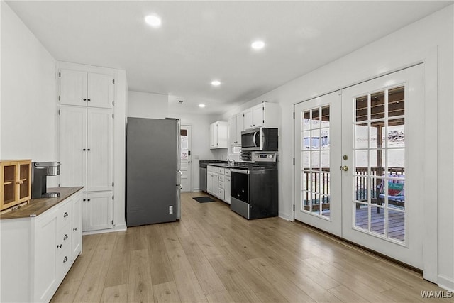 kitchen featuring appliances with stainless steel finishes, french doors, white cabinetry, and light wood finished floors