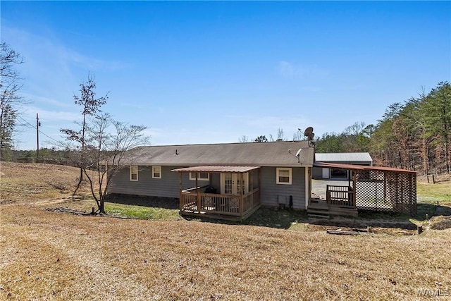 rear view of house featuring a yard and a wooden deck