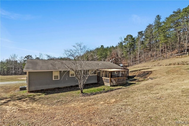 view of front of house with central AC unit and a front lawn