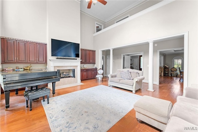 11147 Mountain Park Cir, Tuscaloosa, AL 35405 - living room with a towering ceiling, crown molding, a ceiling fan, ornate columns, and a fireplace with flush hearth