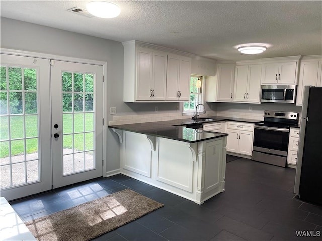 kitchen featuring white cabinets, stainless steel appliances, and a peninsula