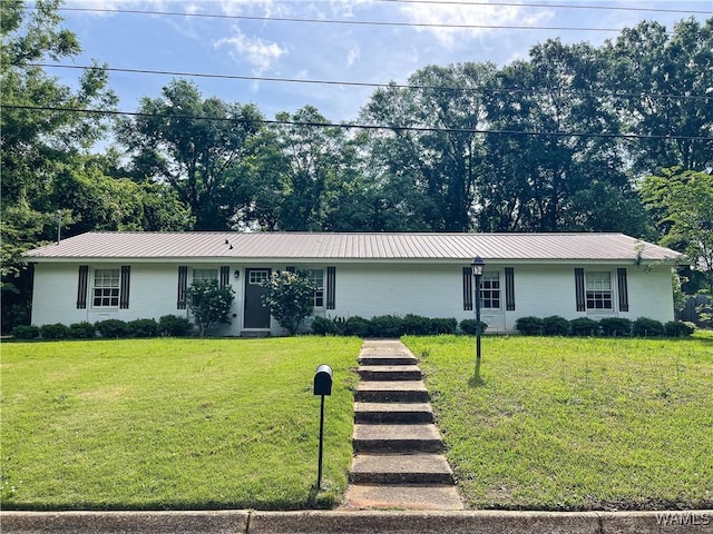 single story home featuring metal roof and a front yard