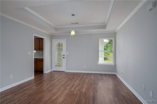 spare room featuring crown molding, dark wood-style flooring, baseboards, and a tray ceiling
