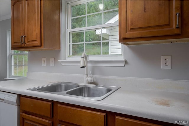 kitchen featuring a sink, light countertops, brown cabinets, and dishwasher