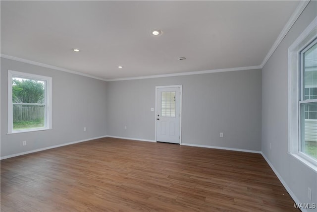 spare room with crown molding, recessed lighting, baseboards, and wood finished floors