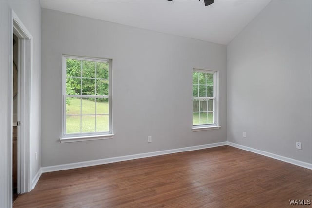 empty room with baseboards, lofted ceiling, wood finished floors, and ceiling fan