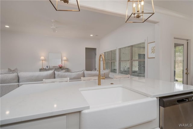 kitchen featuring crown molding, open floor plan, dishwasher, and a sink