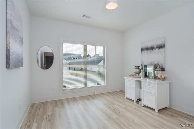 unfurnished office featuring baseboards, visible vents, and light wood finished floors