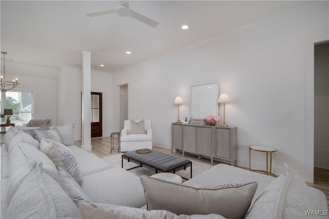 living room featuring baseboards, ceiling fan with notable chandelier, light wood-type flooring, and recessed lighting