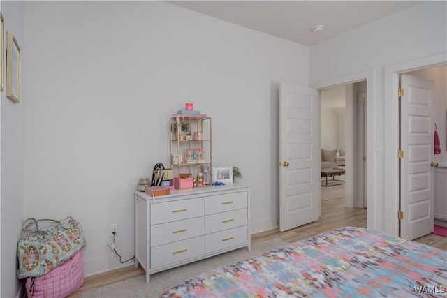 bedroom with light wood-type flooring and baseboards