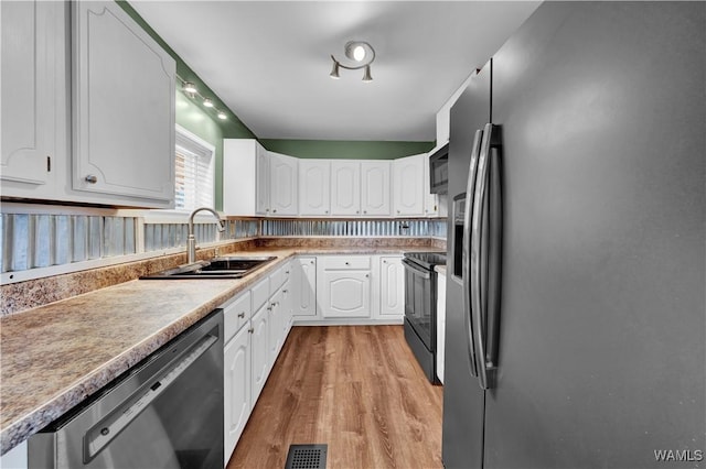 44 Maddox Rd, Nauvoo, AL 35578 - kitchen with visible vents, white cabinets, a sink, light wood-type flooring, and black appliances